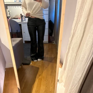 Svarta bootcut byxor i skinnimitation - Säljer ett par svarta byxor i skinnimitation med bootcut-modell. Byxorna är ifrån bershka i stl S. Dom är använda 3 ggr och säljer då jag inte riktigt är bekväm i skinn. Är 161 lång och dom är lite långa på mig men fungerar utmärkt när jag har skor.