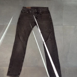 Dondup Jeans - Ett par Grå-brun aktiga Dondup jeans, inga defekter förutom att en tyg bit lossnat i ena fickan man själva fickan är fortfarande funktionell.
