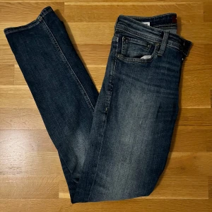 Lee mörkblå jeans - Snygga Lee jeans i mörkblå tvätt med klassisk femficksdesign och smal passform. 
