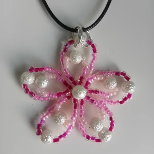 Halsband blomma - Skapat med pärlor i rosa nyanser samt vita. Kedjan är justerbar och aldrig använd.