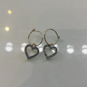 Guldiga örhängen med blå hjärtan - Supersöta örhängen med hjärtan av blå stenar perfekta om du vill ha en söt look!!☺️✌🏻