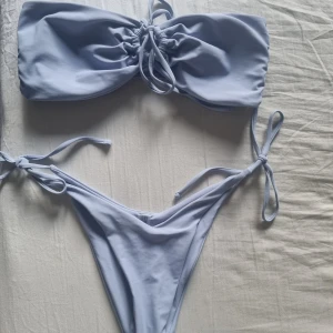Ljusblå bandeau bikini - Oanvänd blå/lila bandeau bikini i strl L. Skulle säga att den passar en M eller L. Jag brukar ha S/M och den var för stor.