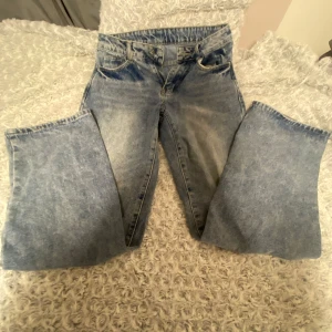 Wide ljusblå jeans med rak passform - Säljer ett par riktigt snygga ljusblå jeans med breda ben och klassisk femficksdesign. Jeansen har en rak och loose fit, perfekt för en avslappnad streetstil. Materialet är klassisk denim och färgen har en cool tvättad look.
