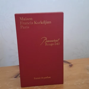 Baccarat Rouge 540 Extrait de Parfum - Lyxig parfym från Maison Francis Kurkdjian, Baccarat Rouge 540 Extrait de Parfum. Flaskan är djup röd med guldfärgad etikett och lock, levereras i elegant röd och vit kartong. En ikonisk doft med exklusiv känsla och snygg design – perfekt för dig som vill sticka ut.