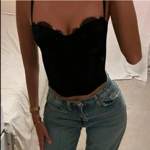 Svart korsettopp med spets - Snygg svart korsett med spetsdetaljer och justerbara axelband. Första bilden är lånad men dem andra är toppen jag säljer!