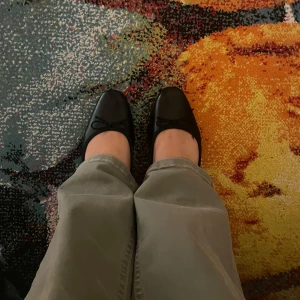 Svarta ballerinaskor med rosett från XIT - Stilrena svarta ballerinaskor från XIT med klassisk rosettdetalj framtill. Skorna har rund tå och platt sula, tillverkade i syntetmaterial. Perfekta för dig som gillar enkel och tidlös stil.