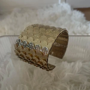 Brett guldig bangle armband med mönster - Stort guldigt bangle armband med unikt mönster