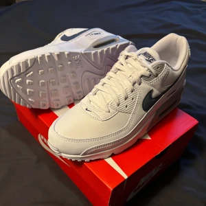 Nike Air Max 90 vita sneakers, med reflex⚡️.priset kan diskuteras - Nike Air Max 90 sneakers i fräsch vit färg med grå och silverdetaljer. Klassisk design med synlig Air Max-dämpning, snörning och rund tå. Ovandel i syntet och textil, sula i gummi. Perfekta för dig som gillar stilrena och sportiga sneakers. Men även är det reflex på Nike märket på sidan för dig som vill synas lite extra!