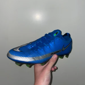 Nike phantom - Säljer ett par nike phantom gt elite fg. Provade cirka 6 gånger och säljer dem för dem inte passar mig. Skorna är sällsynta och tillverkas inte idag därför så är den svåra att få tag på. Skorna är perfekta för att lira i dem är sköna och snygga men även attraktiv för den som samlar på fotbollsskor.