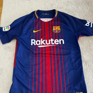 FC Barcelona matchtröja Nike M - Säljer en äkta FC Barcelona matchtröja från Nike, säsong 2017. Tröjan är blå och röd med smala vertikala ränder, klubbmärke på bröstet och Rakuten som sponsor. Tillverkad i Dri-FIT-material som andas. Kortärmad modell med La Liga-märke på ärmen. I mycket fint skick , då den är knappt använd. Mest varit samlingsmaterial. Hör av er vid eventuella frågor , mvh.