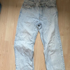 Ljusblå Levis 501 jeans straight fit - Säljer ett par klassiska ljusblå jeans med raka ben och hög midja. Jeansen har fem fickor, knappgylf och är tillverkade i robust denim. Perfekta för en avslappnad och tidlös stil.