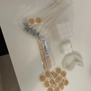 LJUS  - Bilden visar ett DIY-kit för att göra ljus, inklusive vekar, formar, etiketter och träpinnar. 