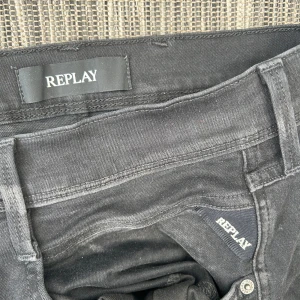 Svarta Replay Anbass jeans slim fit - Svarta jeans från Replay, modell Anbass, med slim fit och klassisk femficksdesign. Jeansen är tillverkade i ett stretchigt jeansmaterial och har snygga detaljer som Replay-logga på fickan och knapp. Perfekta för en clean och stilren look. Knappt använda så riktigt schysst sicka på dom också 🤗🤗