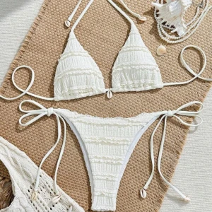 Vit bikini med snörning och volang - Aldrig använd bara testad. Lågmidjade trosor. Jätte söt.  Superfin vit bikini med volangdetaljer och snörning i både över- och underdel. Triangeltopp med knyt i nacken och ryggen, samt bikinitrosa med knyt i sidorna. Dekorerad med små snäckor för en extra beachy vibe. Perfekt för sommaren!