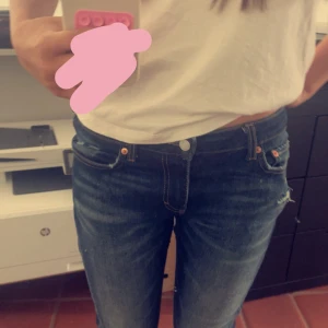 Mörkblå jeansbyxor från weekday - Säljer ett par klassiska mörkblå jeansbyxor från weekday med fem fickor och orange sömmar. Byxorna har normal passform och låg midja, perfekt till vardags. Stängs med dragkedja och knapp framtill.