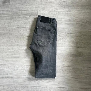 Jack and Jones Jeans - Säljer ett par grå jeans med klassisk femficksdesign och raka ben. Jeansen har normal passform och är tillverkade i ett mjukt denimtyg. Perfekta för dig som gillar en stilren och enkel look.stolek 30/30 skick 9/10 använda fåtal gånger 