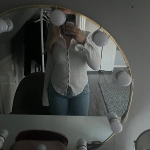 Vit skjorta med knappar - Säljer en klassisk vit skjorta med långa ärmar och knappar framtill. Skjortan har en normal passform och är tillverkad i ett lätt material som passar perfekt till jeans eller kjol.