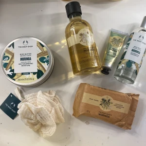 The Body Shop Moringa set - Ett kit med Moringa-produkter från The Body Shop: body butter, duschgel, handkräm, body mist och tvål. Alla produkter har en fräsch blommig doft av moringa. Inkluderar även en vit badsvamp-accessoar. Alla produkter är oanvända 