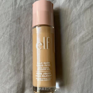 e.l.f. Halo Glow  - Glow booster i flytande form från e.l.f. i nyansen Shade 2 Fair/Light. Ger en strålande finish och kan användas ensam eller under foundation. Kommer i en glasflaska med rosa lock och rymmer 31,5 ml. HELT NY, oanvänd och oöppnad.