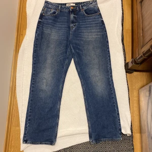 Blå jeansbyxor från JDY large längd 32 - Klassiska blå jeansbyxor från JDY med normal passform och raka ben. Byxorna har fem fickor, bälteshällor och stängs med dragkedja och knapp. Perfekta till vardags och enkla att matcha med olika toppar.
