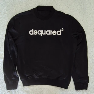 Svart sweatshirt från Dsquared2 M - Svart Dsquared2 tröja med vit logga tryckt på bröstet. Tröjan har rund halsringning och långa ärmar med ribbade muddar vid ärmslut och nederkant. Perfekt för en stilren och avslappnad look. I Mycket bra skick, liten M.