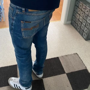 Blå jeans från Nudie Jeans - Säljer ett par blå jeans från Nudie Jeans, modellen Lean Dean. Jeansen har klassisk femficksdesign, orangea sömmar och en snygg tvätt. Materialet är 99% bomull och 1% elastan. Han på bilden är ca182, tveka inte att kontakta vid eventuella frågor 😀