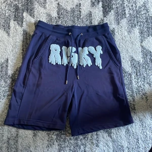 Risky shorts - Säljer ett par mörkblå shorts från Risky med stort vitt tryck framtill. Shortsen är storlek M men passar för L också, bara använda en gång och tvättade. Pris kan diskuteras