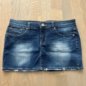Mörkblå jeanskjol - Snygg jeanskjol i mycket bra skick. Köpt utomlands därav är storleken större. Men den sitter som st S på mig som brukar ha st S. Midjemåttet rakt över är 40c