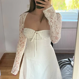 Vit spetsklänning med snörning - Superfin vit klänning med långa spetsärmar och snörning både fram och bak. Figurnära passform upptill. Perfekt för somriga tillfällen eller student. Säljer då jag själv hittat en annan studentklänning. Den var dessutom lite för stor vid bysten för mig. Fanns ingen lapp som kom med klänningen, men när jag tittade på min beställning stod det att storleken är M, skulle dock säga att den är mer åt en S. Knytband i ryggen som gör att man kan ju justera hur tajt man vill att den ska sitta 💗