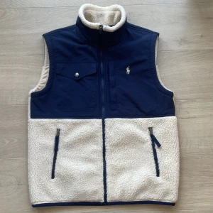 Ralph Lauren fleeceväst  - Säljer nu en riktigt schysst fleeceväst från Ralph Lauren. Västen är i toppenskick 9/10, och inga defekter förekommer! Modellen på bilden är 183 cm lång och väger kring 70 kg. Hör av dig vid intresse! 💫 