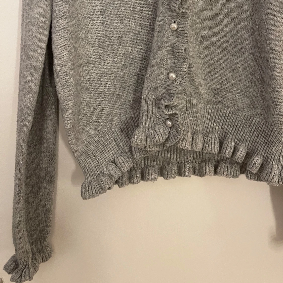 Grå stickad kofta med volang och pärlknappar - 1