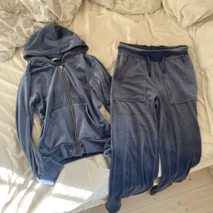 Blå velour hoodie och byxor set - Mysigt set med hoodie och byxor i blå velour. Hoodien har dragkedja och fickor, byxorna har resår i midjan och dragsko. Perfekt för en avslappnad stil eller hemmamys.