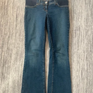 Blå bootcut byxor från Next Jeans - Säljer ett par blå bootcut från Next Jeans med  stretchpanel över magen. Klassisk femficksmodell med knapp och dragkedja framtill. 