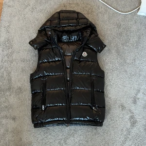 Moncler väst  - Hej. Säljer denna snygga moncler västen. Den är nyligen köpt. Och endast använd 2-3 gånger. Skicket är som nytt och storleken är M. Sitter som S. Passar mig bra som är 178. Säljer då jag inte diggade plagget och är intresserad av andra plagg ist. Hör av dig för flera frågor. Lägg prisförslag. 