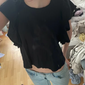 Svart  topp med volangärmar från Zara - Säljer en svart topp från Zara med stora volangärmar. Toppen har rund halsringning och är tillverkad i ett mjukt, lätt material. Perfekt för sommaren dom lite varmare dagarna. Mycket bra skick, hör av dig om du har frågor eller funderingar 💕