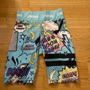 Stronger blå träningsshorts med pop art - 💕Färgglada träningsshorts från Stronger med pop art-inspirerat tryck i blått, gult, rosa och svart💕