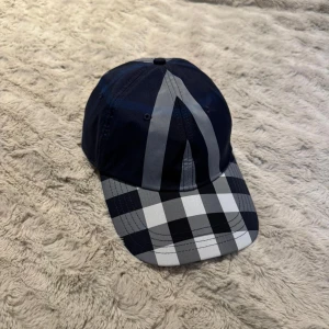 Burberry keps - Säljer denna snygga burberry kepsen i färgen blå och storleken M, helt ny och oanvänd. Priset kan diskuteras vid snabbaffär