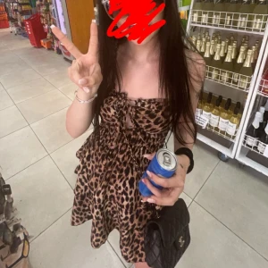 Leopardmönstrad kort klänning med snörning - Supersnygg kort klänning med leopardmönster och smockad midja. söt snörning framtill och volangig kjol. Perfekt för dig som vill sticka ut och köra på en trendig look.