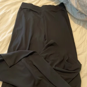 Svarta mjukisbyxor från Reaction - Svarta mjukisbyxor från Reaction i storlek 146/152. Byxorna har en enkel och clean design med resår i midjan och raka ben. Perfekta för chill dagar eller när du vill ha det extra bekvämt.