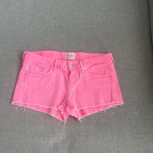 Rosa jeansshorts  - Snygga rosa jeansshorts från Pepe Jeans med råa, fransiga kanter och klassisk femficksmodell. Shortsen har låg midja och är perfekta för sommaren. Storlek 27 💓. Sitter som XS och S. Har nån defekt på ena bakficka och ett lila streck. (Om man kollar på första bilden där strecket är ser man inget tydligt)