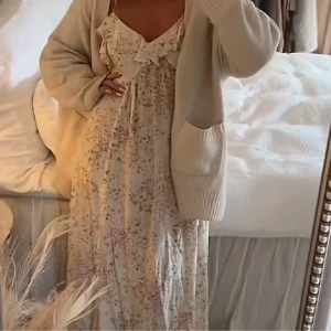 Blommig långklänning från hm - Superfin långklänning i ljusa toner med blommigt mönster och tunna axelband. Klänningen har v-ringning med volangdetalj framtill och är perfekt för sommarens alla tillfällen. Den passar XS-M.