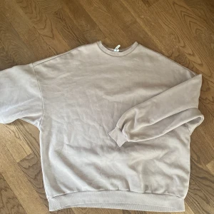 Beige oversized sweatshirt NLY Trend - Enkel och stilren beige sweatshirt från NLY Trend i oversized modell. Tröjan har rund halsringning, långa ärmar och ribbade muddar vid ärmslut och nederkant. 