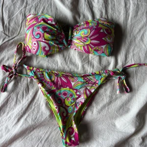 Färgglad bandeau bikini med knyt - Säljer min fina bikini i paisley mönster. Den är köpt förra året på calzedonia🥰 skulle säga att den är i storlek S. Priset kan diskuteras!!
