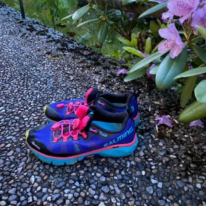 Salming löparskor i blått och rosa - Färgstarka löparskor från Salming i blått med rosa detaljer och snörning. Skorna har svarta och turkosa inslag, samt robust sula för bra grepp. 