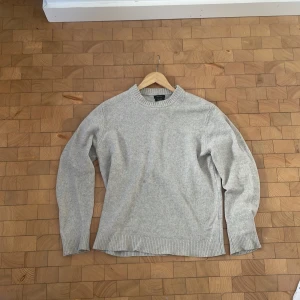 Ljusgrå kashmirtröja Massimo Dutti - Supermjuk ljusgrå stickad tröja från Massimo Dutti i kashmir och ull. Klassisk rund halsringning, ribbade muddar och nederkant. Perfekt för lager-på-lager och chill tröja. Perfekt om det blir lite kyligt en sommarkväll.