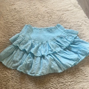 Blå volang kjol - Super söt ljus blå kjol med volanger köpt i Miami perfekt till sommaren! 🩵Har inbyggda shorts och ett stretchigt material i midjan! 