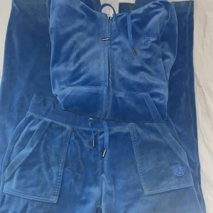 Blått Juicy Couture set - Blått juicy sett, säljer för får ingen användning längre. Koftan är köpt för 1200 o byxor för 1100 men säljer hela sätten för 1000. Dem är använda men har inga skavanker, alla knappar och sånt är kvar! 