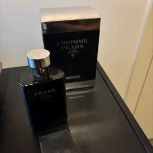 Prada L'Homme Intense 100ml EdP - Prada L'Homme Intense är en lyxig herrparfym i en elegant svart flaska med silverdetaljer. Flaskan rymmer 100 ml och har en stilren, maskulin design. Doften är djup och intensiv, perfekt för dig som gillar exklusiva och moderna parfymer.
