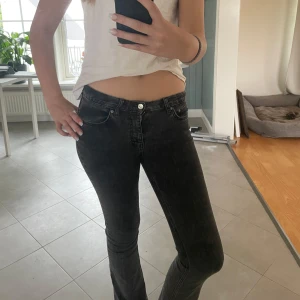 Svarta lågmidjade jeans - Säljer ett par svarta jeans med låg midja. Jeansen har en smal passform och är tillverkade i stretchigt denimtyg som sitter snyggt på kroppen. Perfekta för dig som gillar en enkel och stilren look.