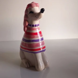 Porslin prydnad - 🐩 Porslinsprydnad, pudel i klänning Hur söt är inte den här lilla porslinspudeln? Köpt i Turkiet redan 2009, så den är ganska speciell och inget man bara hittar igen. Perfekt som en liten färgklick i rummet eller till dig som gillar unika detaljer.  ✔️ I fint skick ✔️ Gjord i keramik/porslin ✔️ Går inte längre att få tag på  💬 Skicka gärna ett meddelande om du undrar något